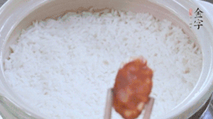 煮開后轉(zhuǎn)小火，當(dāng)米飯出現(xiàn)小孔時(shí)，鋪上金字麻辣香腸。