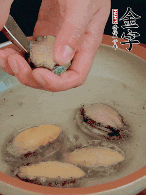 鮑魚加鹽、清水浸泡，用勺子挖出鮑魚肉。