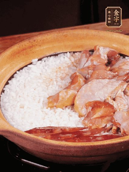 煮到椰子水微微收干轉(zhuǎn)小火，快速均勻鋪上雞肉、金字香腸